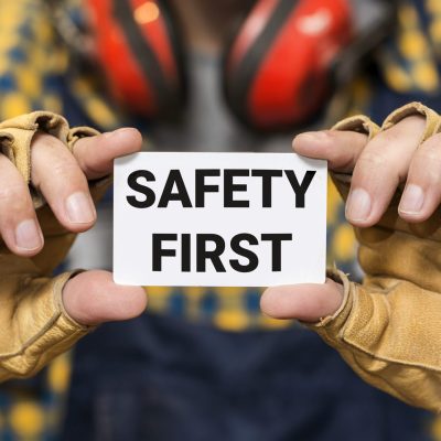 front-view-hands-holding-safety-first-sign front-view-hands-holding-safety-first-sign